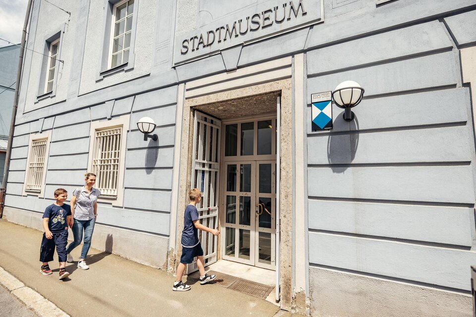 Ein Stadtmuseum mit einer hellblauen Fassade. Eine Familie mit Kindern betritt das Museum. | © Wolfgang Spekner