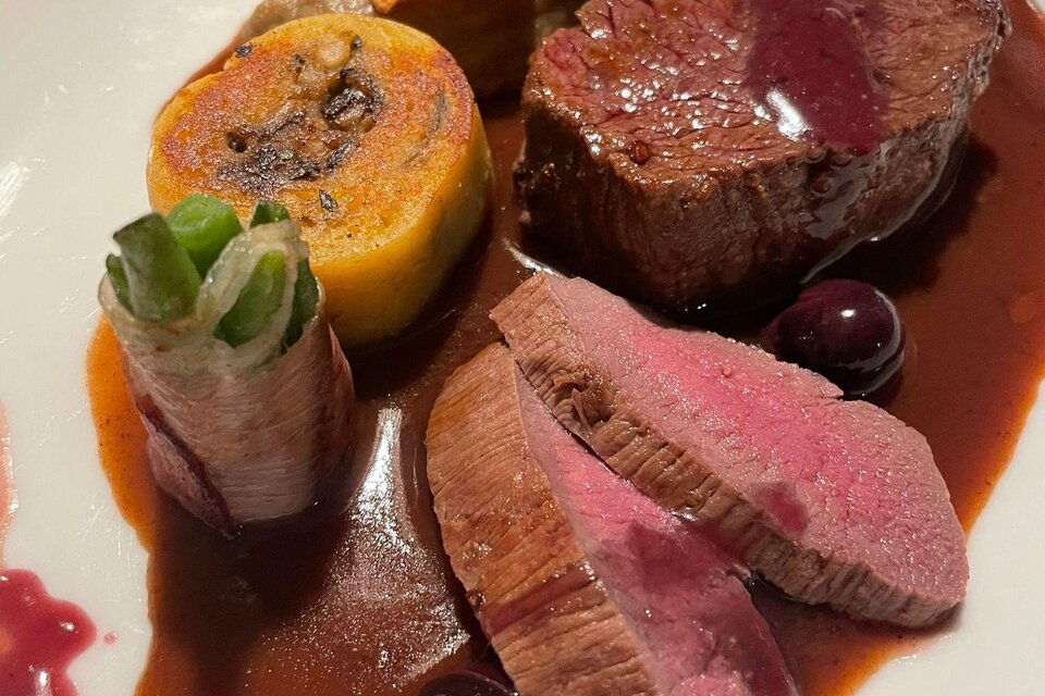Ein kunstvoll angerichteter Teller mit zartem Fleisch, frischem Gemüse und einer roten Sauce. Die Speisen sind ansprechend präsentiert und laden zum Genießen ein. | © Winterleitenhütte